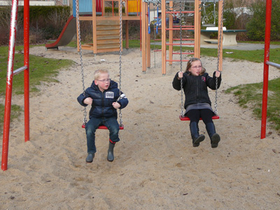 Kyra en Jasper aan het schommelen op het speelterrein in Lelystad